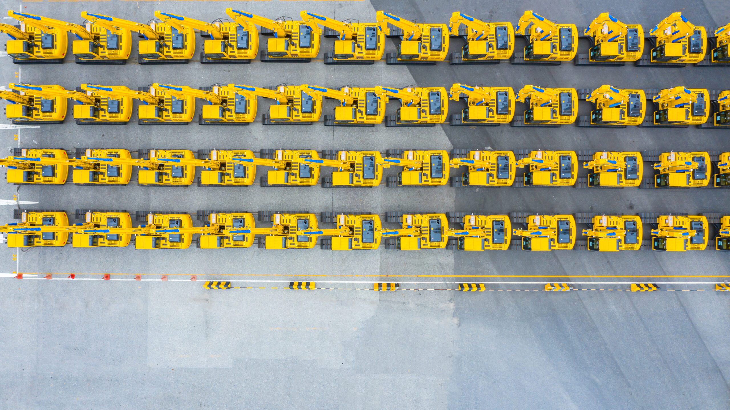 Excavator construction vehicles lined up in an aerial view to illustrate Custom Hydraulic Manifolds