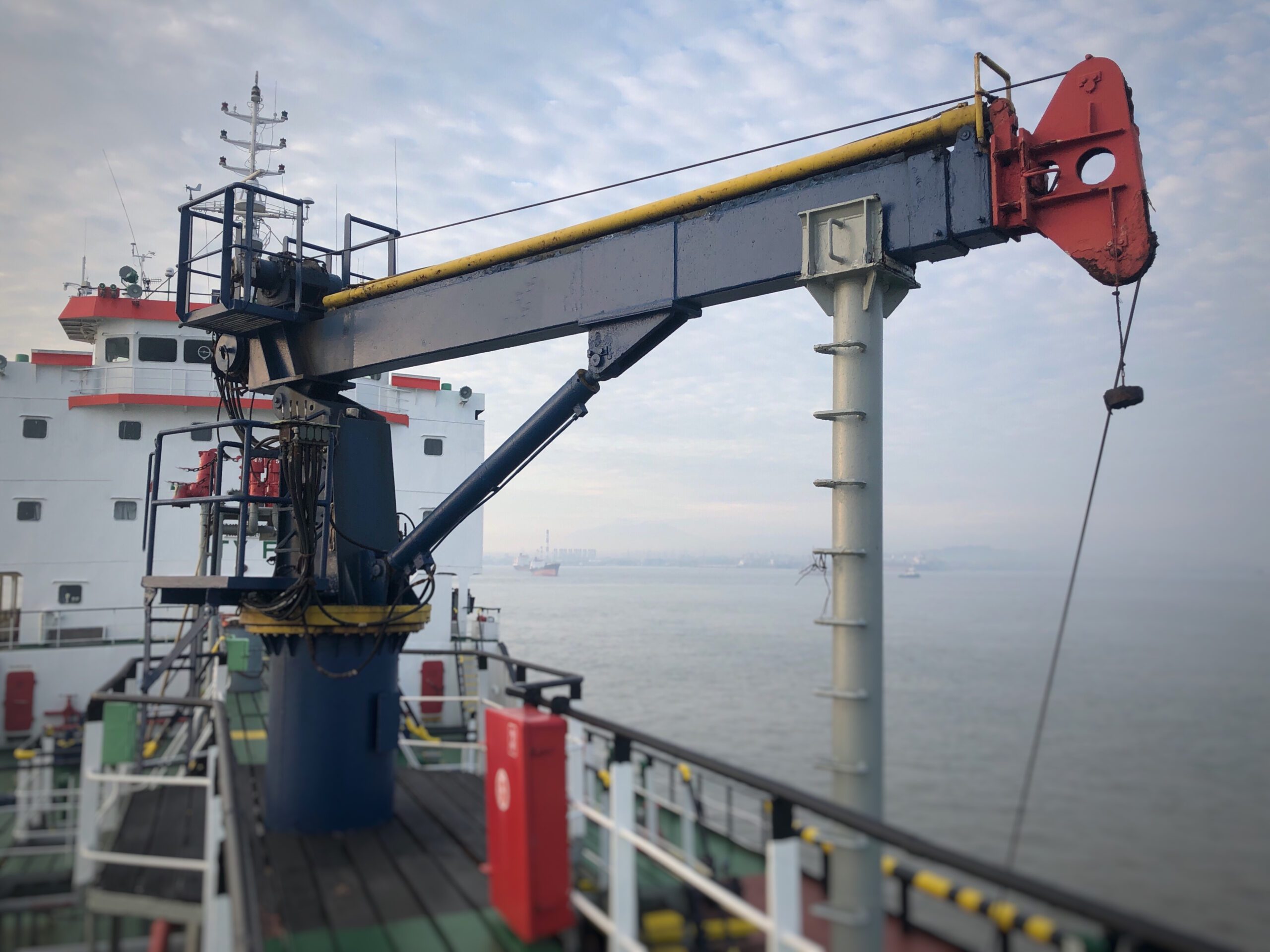 Hydraulic crane on a tanker vessel for efficient cargo lifting and handling.